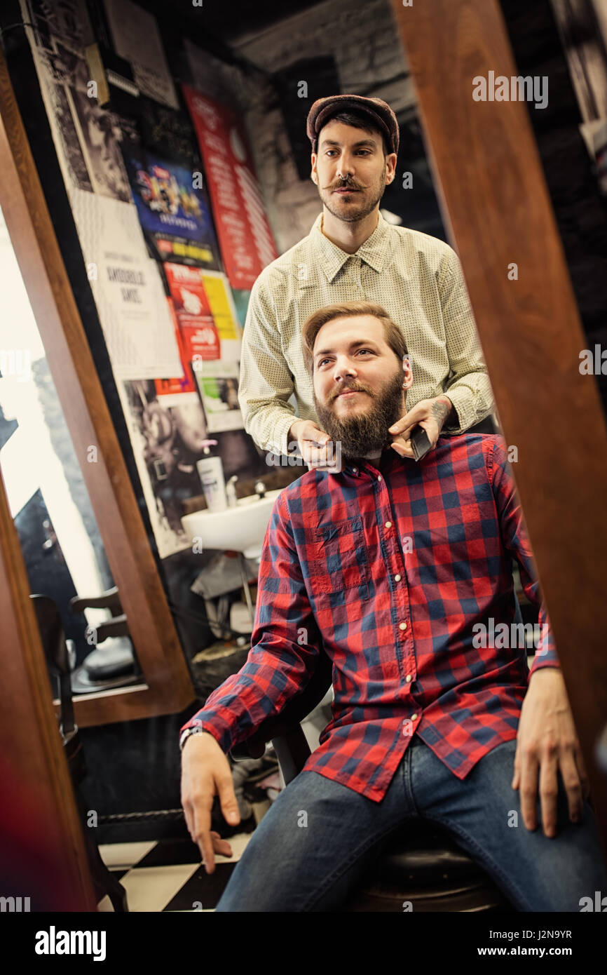 Männliche Friseur Symmetrie Bart auf Client überprüfen Stockfoto