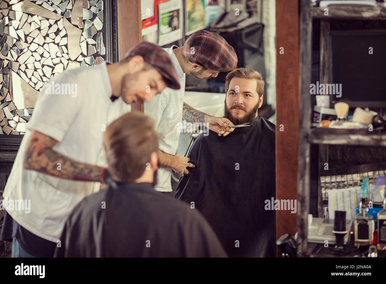 Mann-Friseur mit einer Schere schneiden den Bart lächelnd client Stockfoto