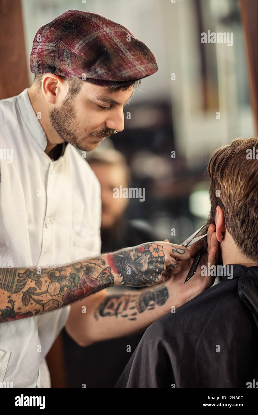 professioneller Friseur mit einer Schere schneiden Sie den Bart des Clients Stockfoto
