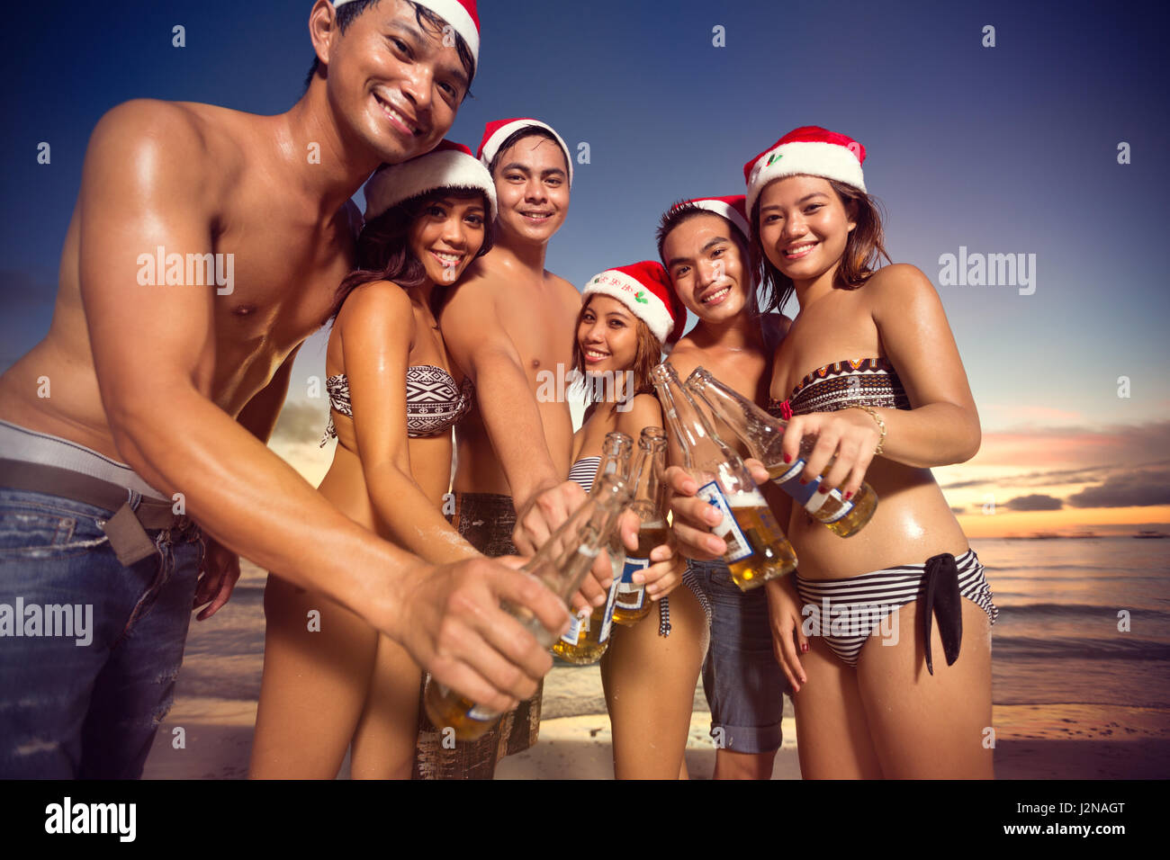 Gruppe der happy Friends mit Santa Hüte Toasten Stockfoto