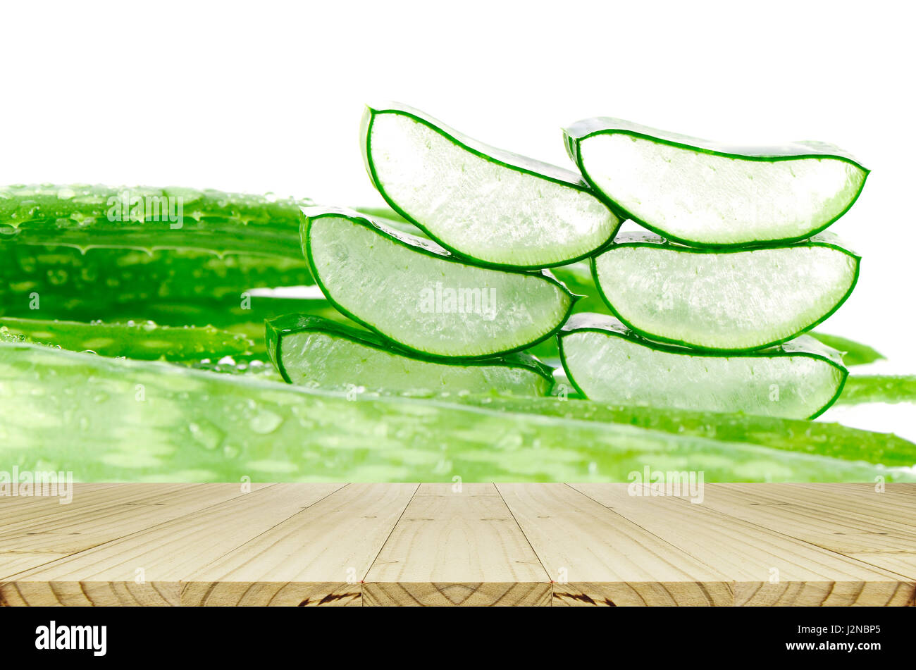 Slice Aloe Vera Blätter Hintergrund mit Regentropfen und Holztisch. Stockfoto