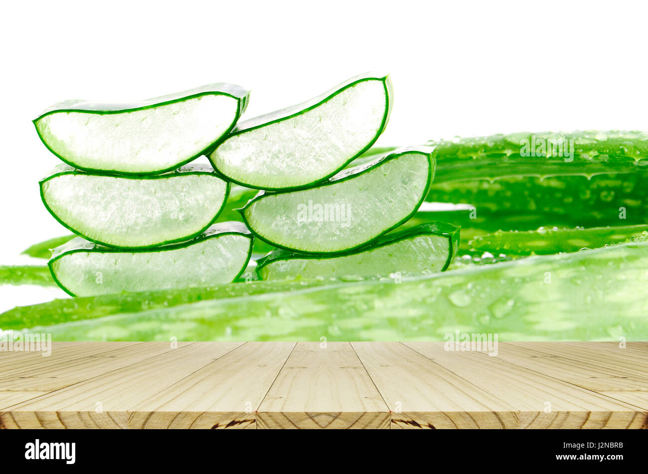 Slice Aloe Vera Blätter Hintergrund mit Regentropfen und Holztisch. Stockfoto