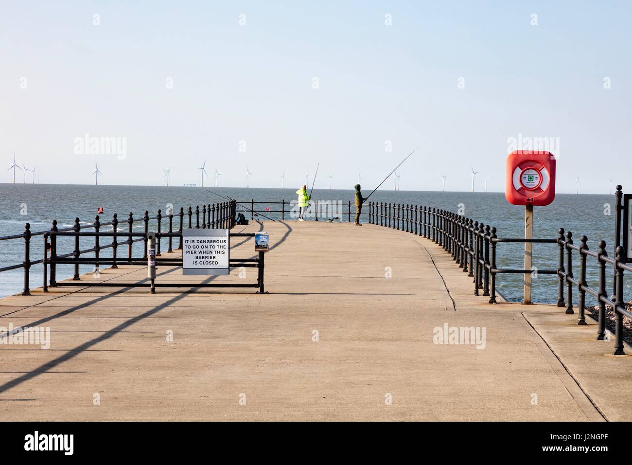 Herne Bay, Kent, UK. 29. April 2017. UK-Wetternachrichten.  Ein sonniger Abend am ersten Tag der Mayday Bank Holiday Wochenende ermöglicht es Menschen, die an den Strand zu gehen, obwohl sie gegen die Kälte verpackt bleiben. Zwei Angler Fischen abseits den Pier in Hampton. Bildnachweis: Richard Donovan/Live Alamy News Stockfoto