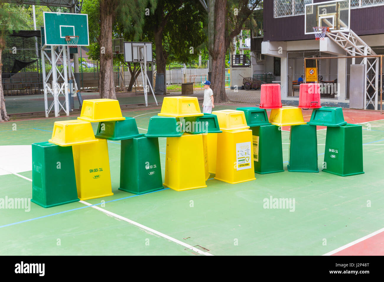 CHIANG MAI, THAILAND - 2. August 2016 - Müll und Recycling-Behälter sind links, um auf einem Basketballfeld im Freien an einer Schule in Chiang Mai Thai außerhalb trocken Stockfoto