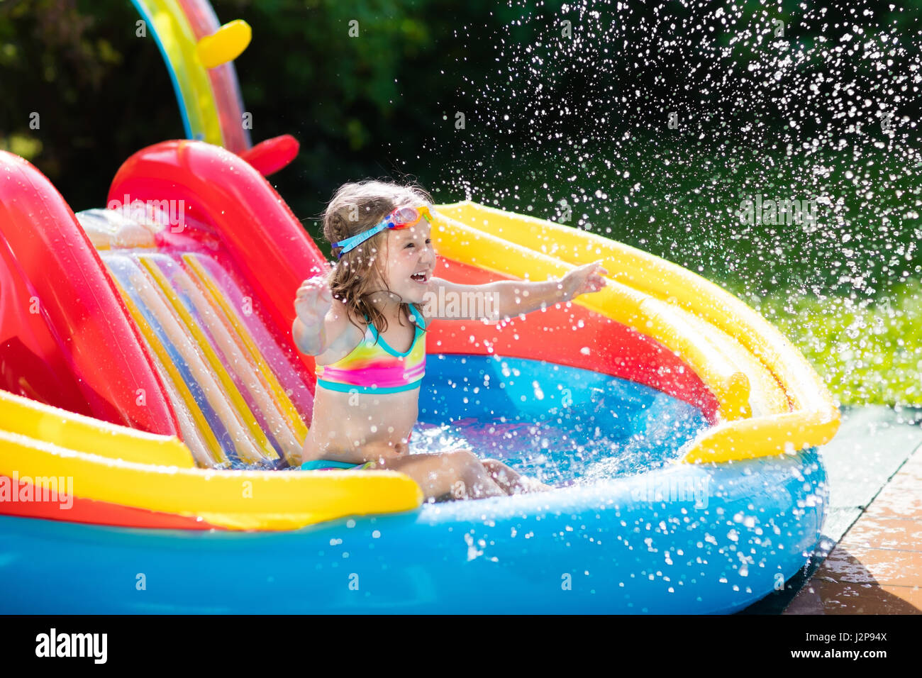 Kind spielt im aufblasbaren Babybecken. Kinder schwimmen, Rutsche und