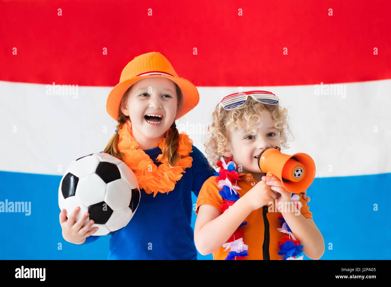 Kinder jubeln und Unterstützung der niederländischen Fußball-Nationalmannschaft. Kinder-Fans und Unterstützer der Niederlande während der Fußball-Europameisterschaft. Junge und Mädchen aus Hollan Stockfoto