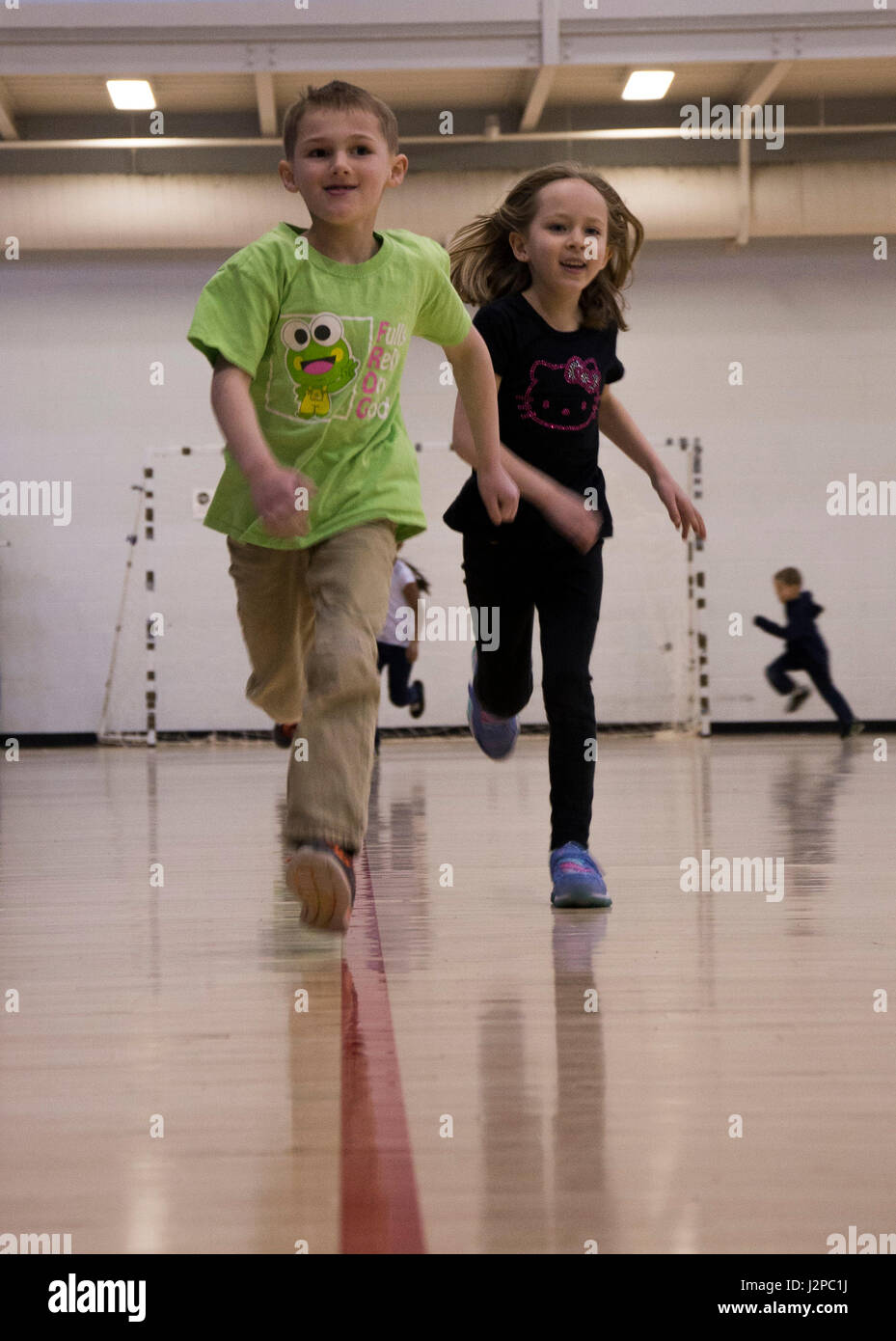 Jugendzentrum Kinder Rennen rund um Basketball Gerichte während ein mock Fitness-Test am McAdoo Fitness Center der Minot Air Force Base, N.D., 17. April 2017. Das Fitness-Center Gastgeber der Veranstaltung für die Kinder zu eine gesunde Lebensweise in Kinder im schulpflichtigen Alter zu fördern. (U.S. Air Force Photo/Flieger 1. Klasse Alyssa M. Akers) Stockfoto