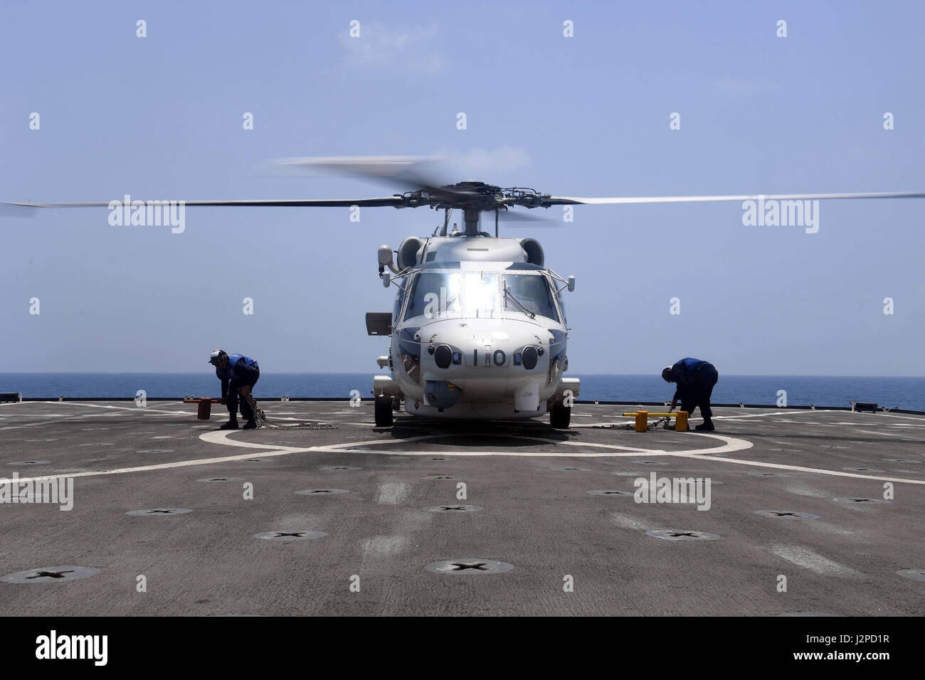 170420-N-ME988-637 5. Flotte AREA OF OPERATIONS (20. April 2017) Seeleute an Bord der amphibischen Dock Landungsschiff USS Carter Hall (LSD 50) entfernt Unterlegkeile und Ketten aus einem Japan Maritime Self-Defense Force (JMSDF) SH-60J Seahawk-Hubschrauber auf dem Schiffsdeck Flug während der Pirateriebekämpfung Validierung Übung 2017. Die Übung bot Gelegenheit für die US Navy Schiffe aus der Republik Korea Navy, Royal Navy und die Japan Maritime Self-Defense Force (JMSDF) Partner, Interoperabilität durch Kommunikation und Pirateriebekämpfung Betrieb Übungen verbessern. Carter Hall, Bestandteil der Bata Stockfoto