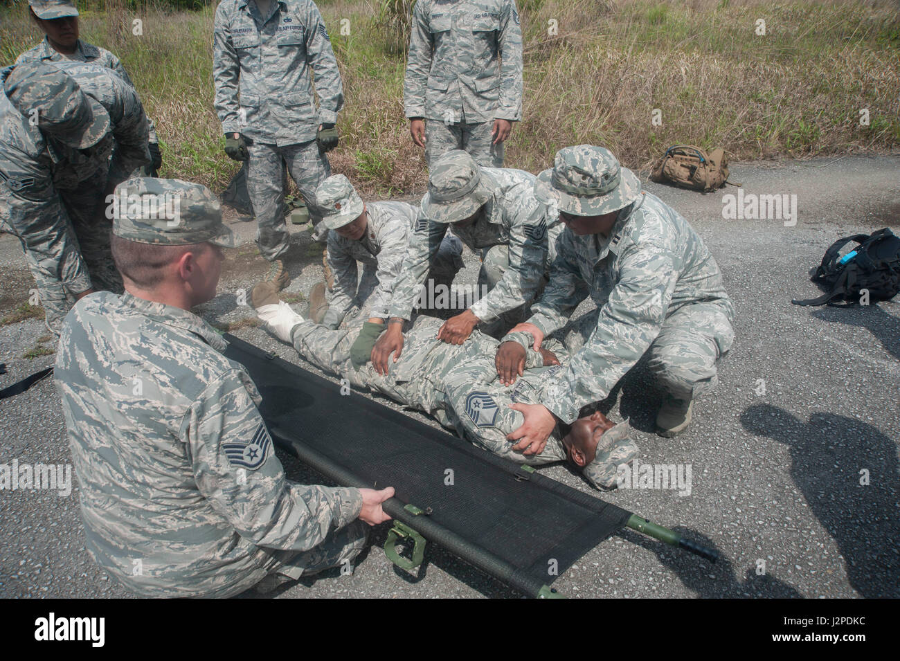 US Air Force Piloten der 18. Medical Gruppe zugewiesen bereiten Sie roll Master Sergeant Ronald Bagley, 18. Medical Group Medizintechniker, auf einen Wurf im Rahmen eines selbst-Hilfe- und Kumpel des 21. April 2017, auf der Kadena Air Base, Japan ausüben. Teilnehmer des präventiven Aerospace Medicine Übereinkommens durchgeführt SABC Szenarien auf simulierten Verluste, einschließlich der Anwendung von Kampf-Action Venenstauer, Bandagen und wie man richtig transportieren Personen auf einen Wurf. (Foto: U.S. Air Force Airman 1st Class Kai Drawdy) Stockfoto