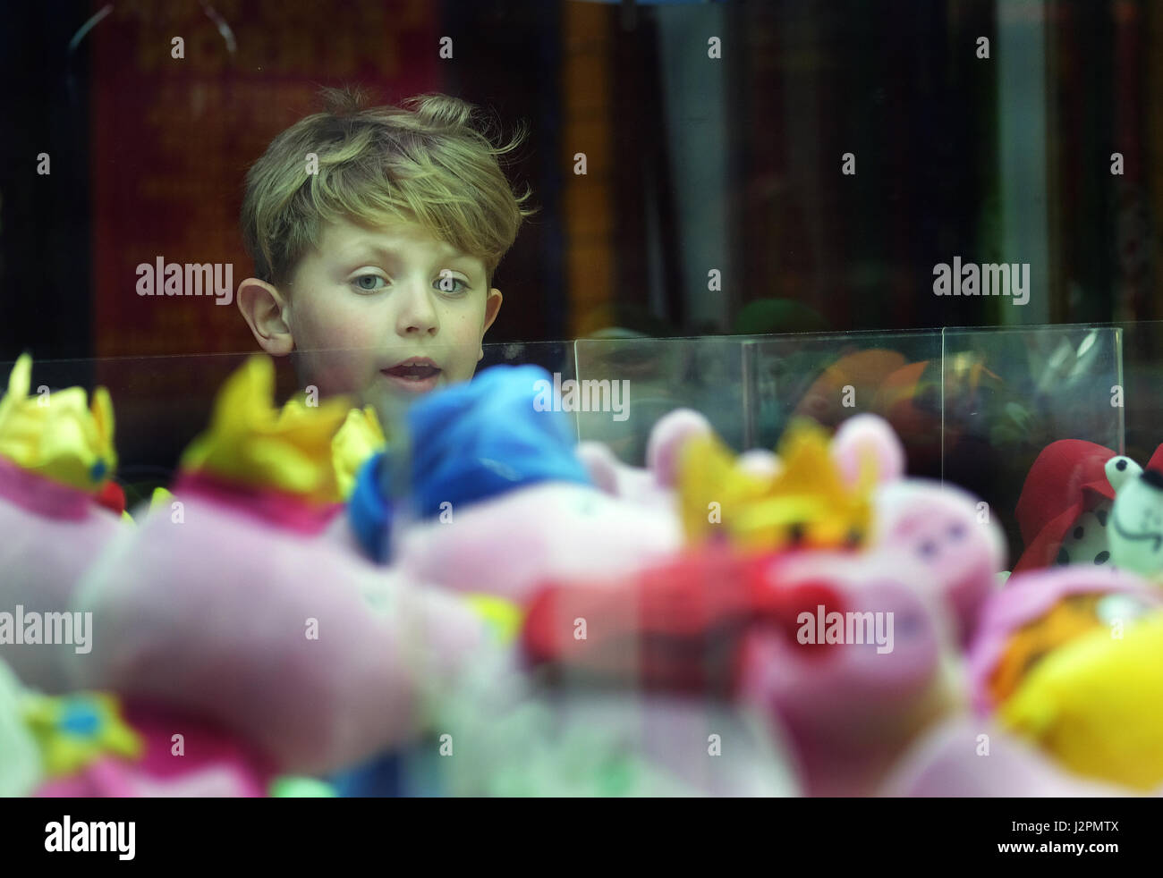 Kind spielt auf Unterhaltung Spielautomaten in einer Spielhalle in den Urlaub. Stockfoto