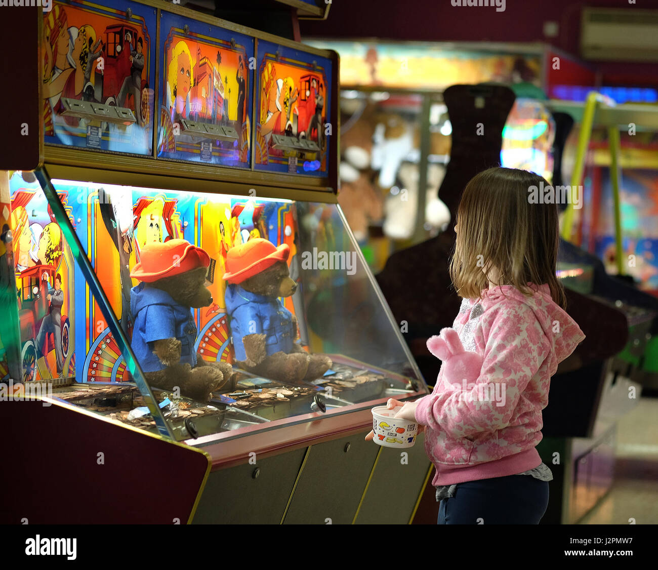 Kind spielt auf Unterhaltung Spielautomaten in einer Spielhalle in den Urlaub. Stockfoto