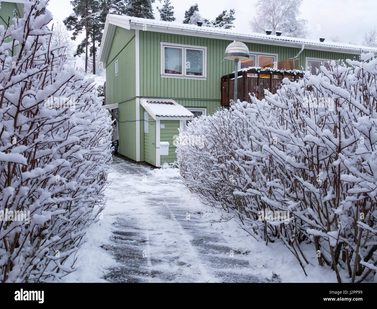 Die Außenseite des typisch schwedische oder skandinavischen grünes Holz Doppelhaushälfte im Schnee im Winter Model Release: Nein Property Release: Ja. Stockfoto