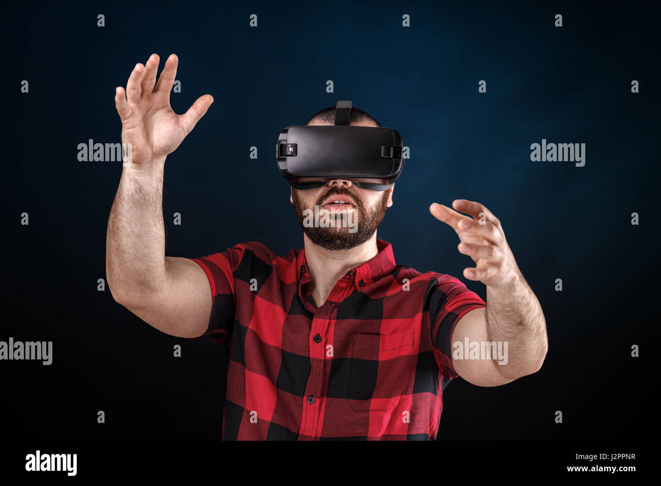 Junger Mann mit VR Brille Kopfhörer versuchen, Objekte in der virtuellen Realität zu berühren. Stockfoto