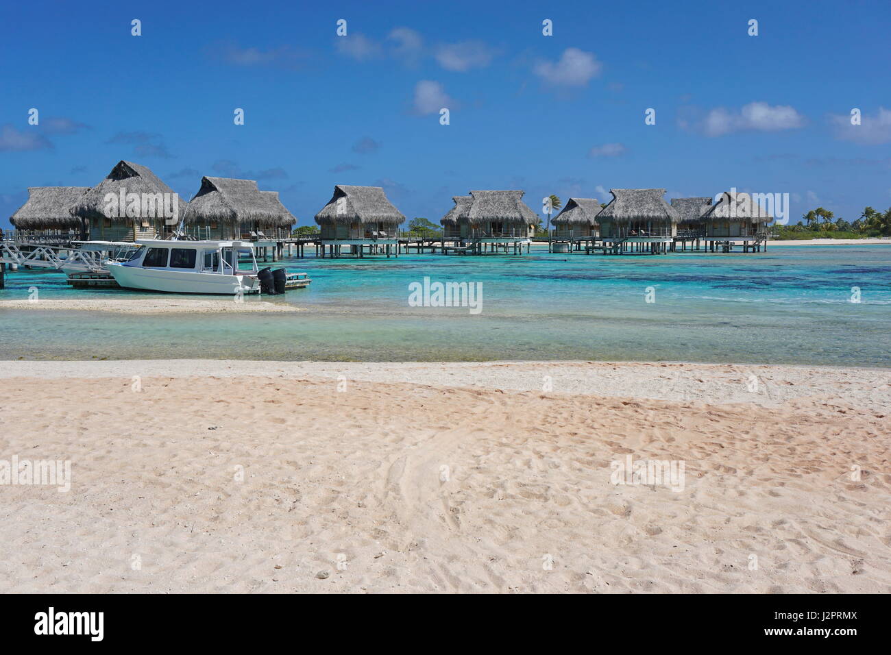 Tropischen Wasserbungalows in der Lagune von einem sandigen Strand, Atoll Tikehau, Tuamotu, Französisch-Polynesien, Süd-Pazifik gesehen Stockfoto