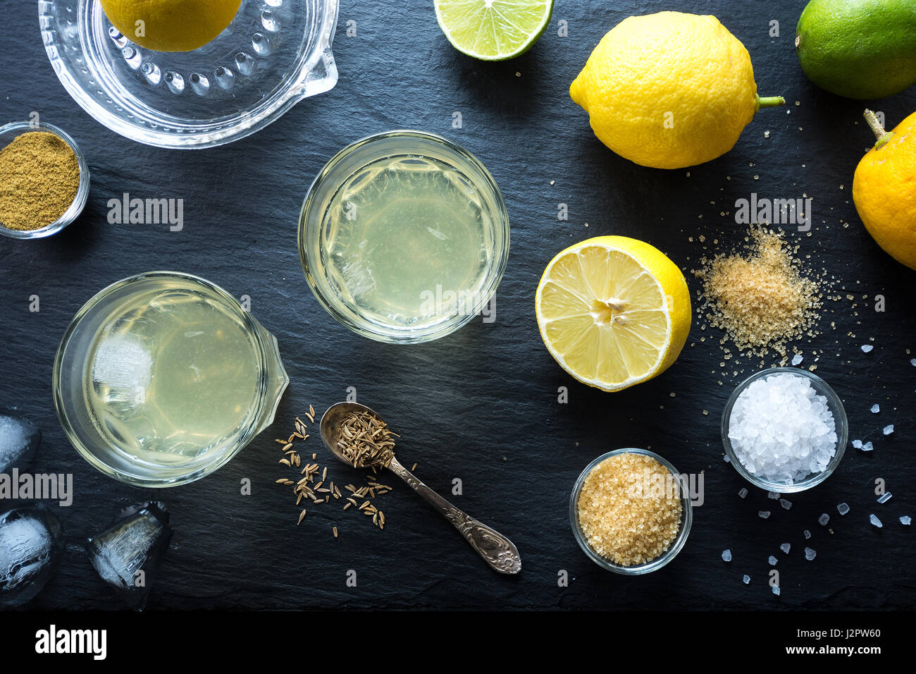 Nimbu Pani indische Limonade, erfrischendes Getränk für heiße Tage. Mit Wasser, Zitronensaft, Zucker, Salz und Kümmel gemacht hausgemacht natürliche isotonische. Ansicht von oben. Stockfoto