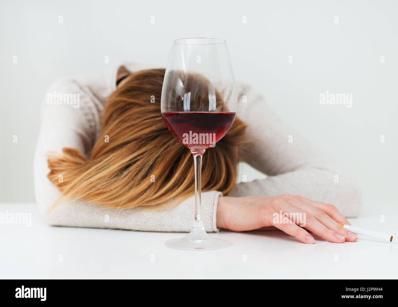 Betrunken Frau schläft auf dem Tisch. Weibliche Alkoholismus. Stockfoto