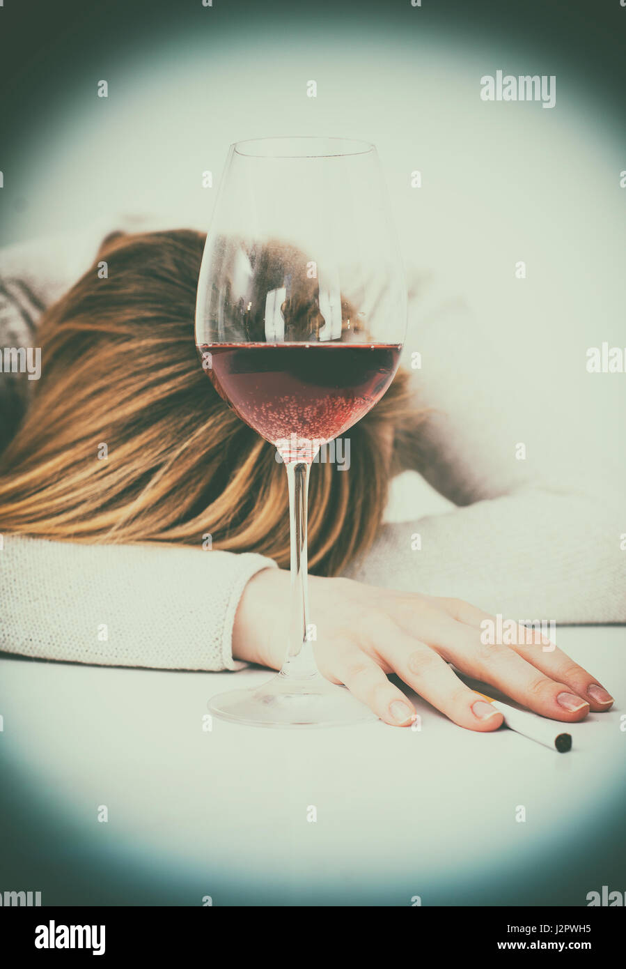 Betrunken Frau schläft auf dem Tisch. Weibliche Alkoholismus. Stockfoto