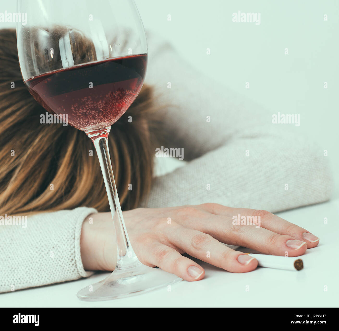 Betrunken Frau schläft auf dem Tisch. Weibliche Alkoholismus. Stockfoto
