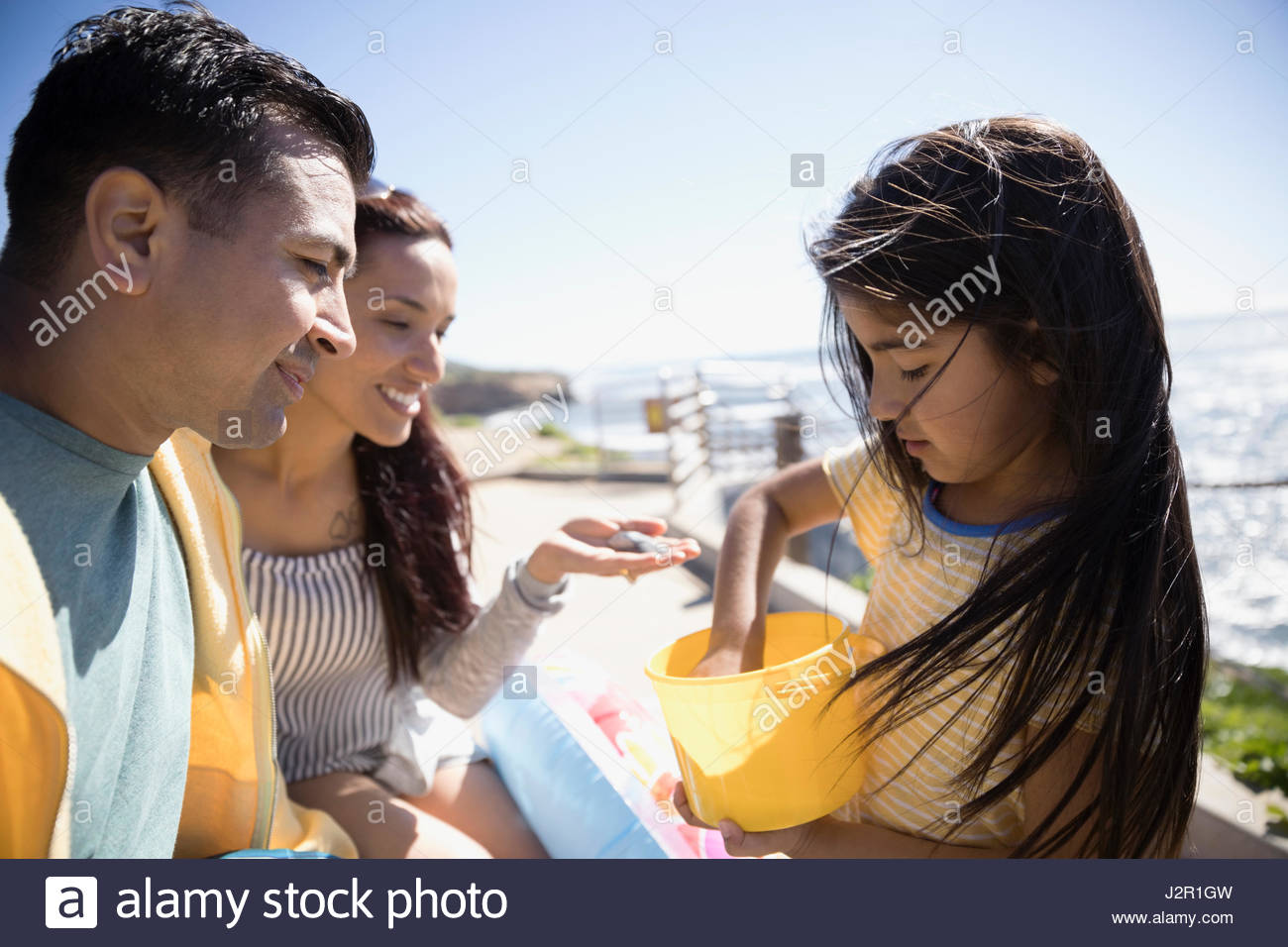 Latino-Tochter mit Muscheln an die Eltern Stockfoto