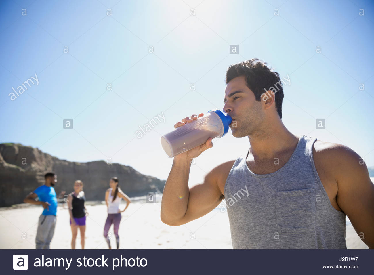 Young östlichen Mittelsmann ausüben, Trinkwasser am Sonnenstrand Stockfoto