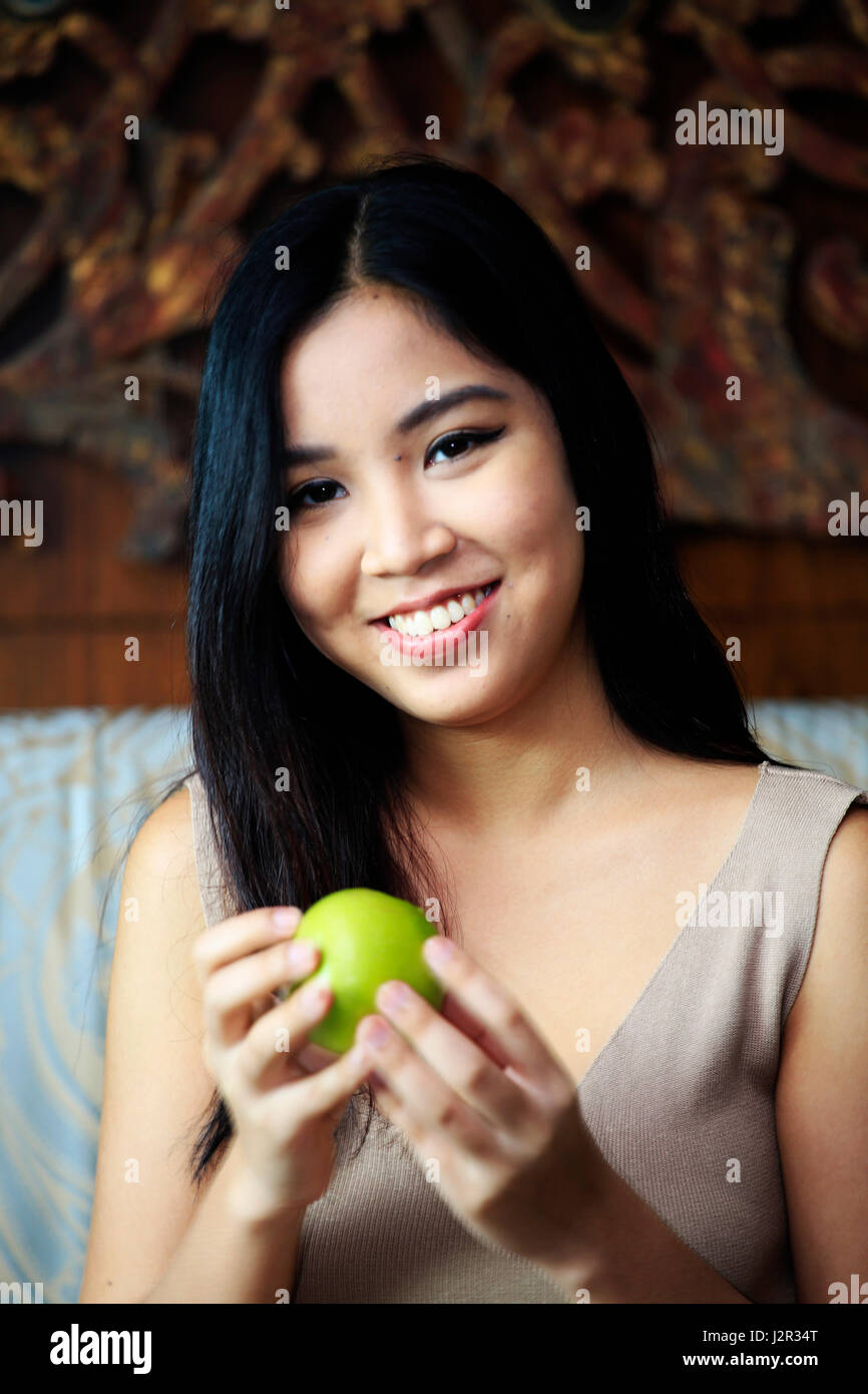 Asiatische Frau hält einen Apfel Stockfoto