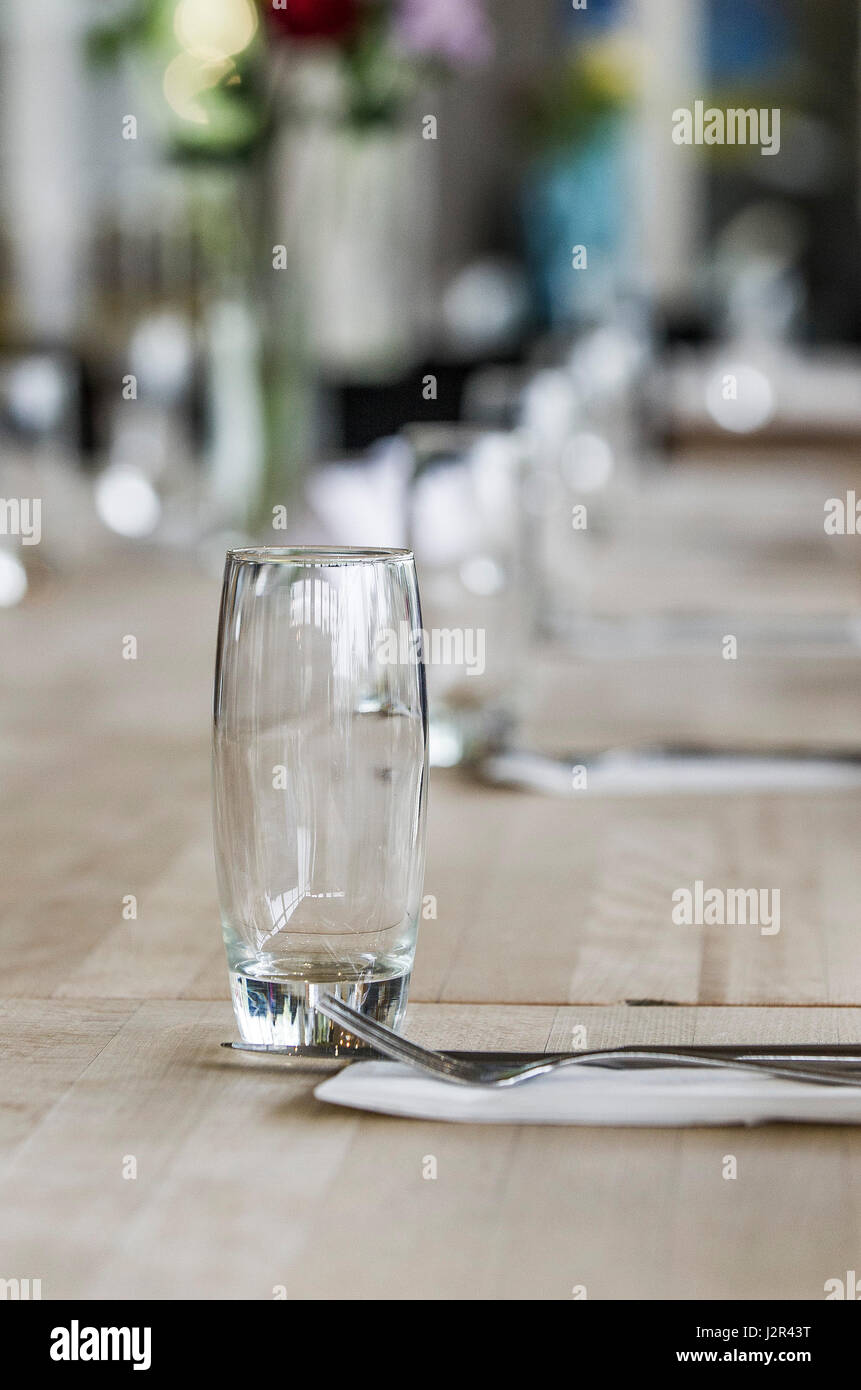 Ein leeres Glas auf einem Esstisch Besteck unbenutzt saubere Restaurant Interieur Stockfoto