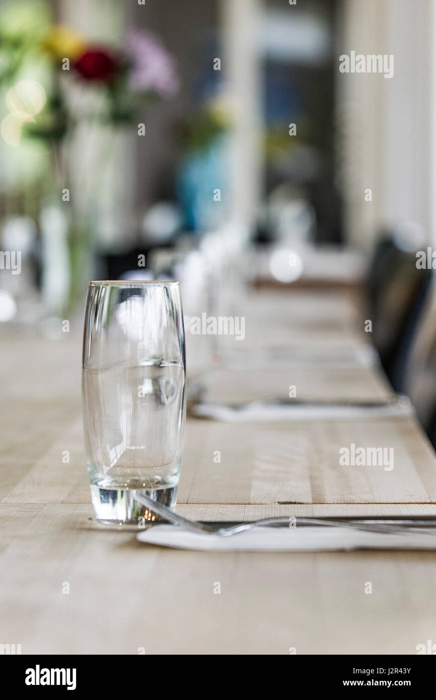 Ein leeres Glas auf einem Esstisch Besteck unbenutzt saubere Restaurant Interieur Stockfoto