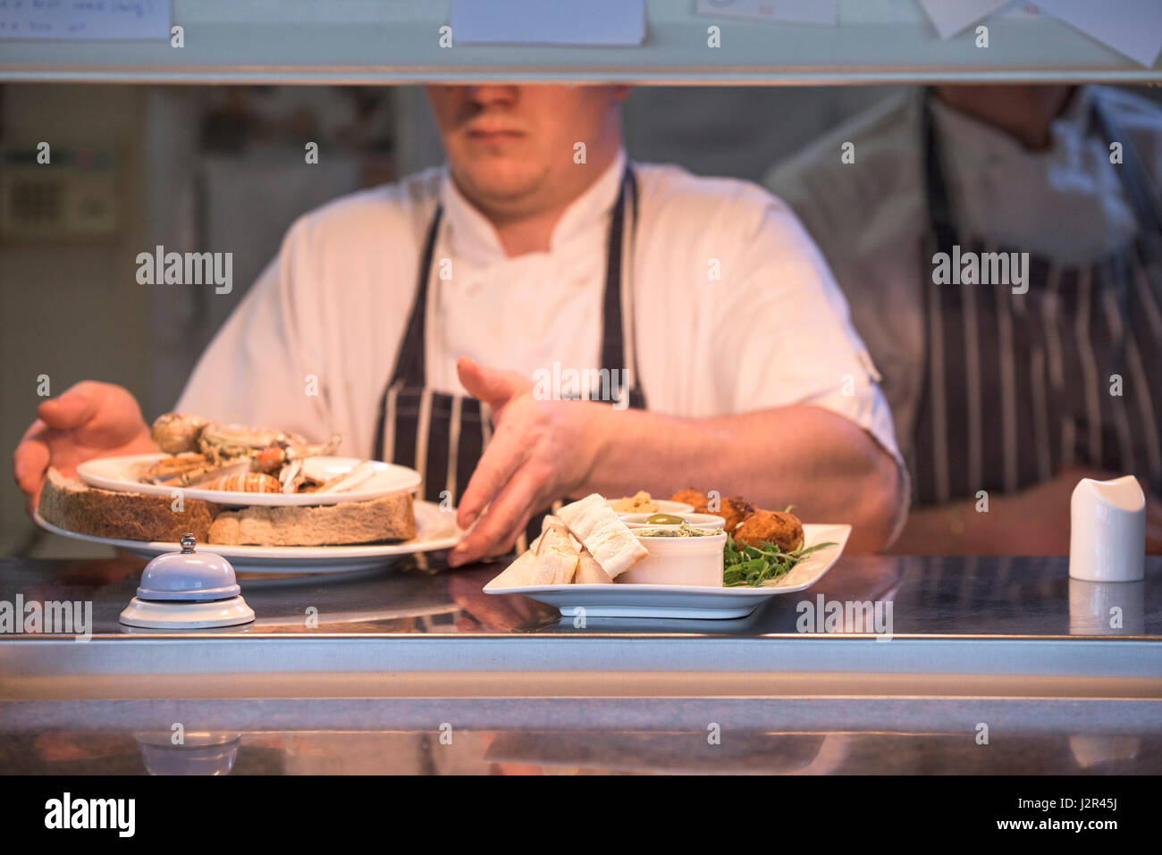Restaurant-Teller mit Essen Durchreiche Lebensmittelzubereitung Chef Mahlzeiten essen Essen service Industrie Gerichte Stockfoto