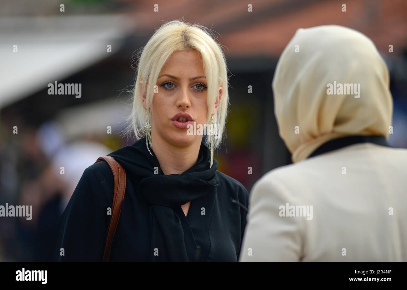 Ein blondes Mädchen im Gespräch mit ihren muslimischen Freund Stockfoto