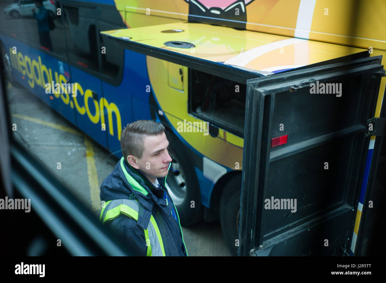 Megabus Fahrer erwartet, Fälle und Passagiere auf seinen Bus am Busbahnhof Aberdeen Scotland zu laden Stockfoto