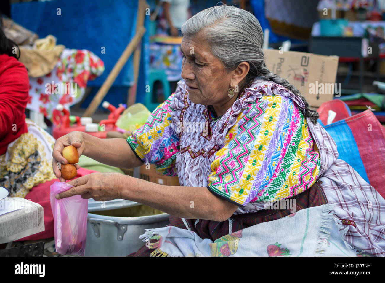 Quetzaltenango, Guatemala - Februar 8, 2015: Maya Frau verkauft süsse Frittierte bunuelos an einem lokalen Lebensmittelmarkt in Xela, Guatemala Stockfoto