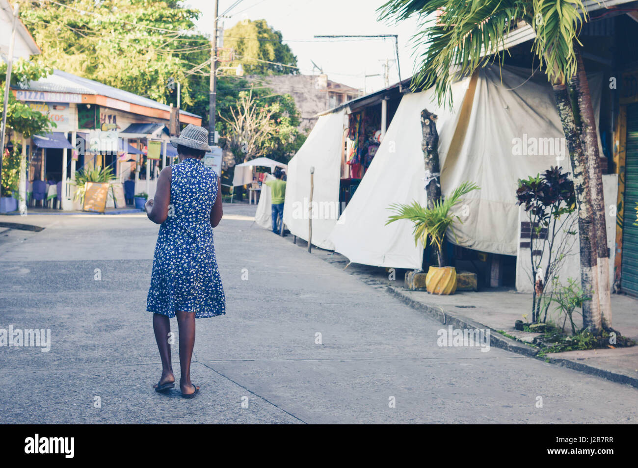 Livingston, Guatemala - 8. März 2015: Garifuna Frau geht auf einer der Hauptstraßen in Livingston, Guatemala. Garifuna sind die Gruppe der indigenen Stockfoto