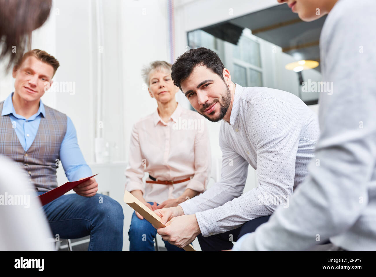 Mann und Gruppe von Geschäftsleuten im Seminar oder Workshop für Team-building Stockfoto