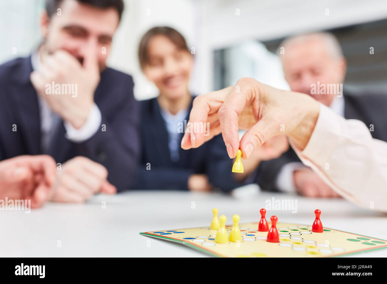 Hand mit token während des Spielens Brettspiel als Business-Strategie-Entscheidung-Konzept Stockfoto