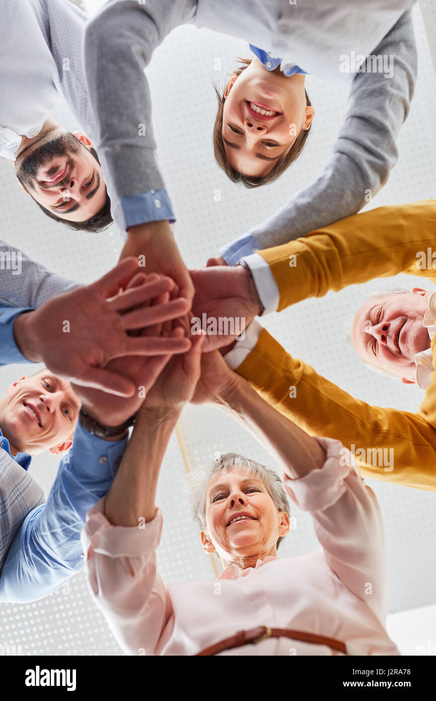 Team macht Übung in Team-building-Seminar Stapeln Hände zusammen für die Motivation Stockfoto