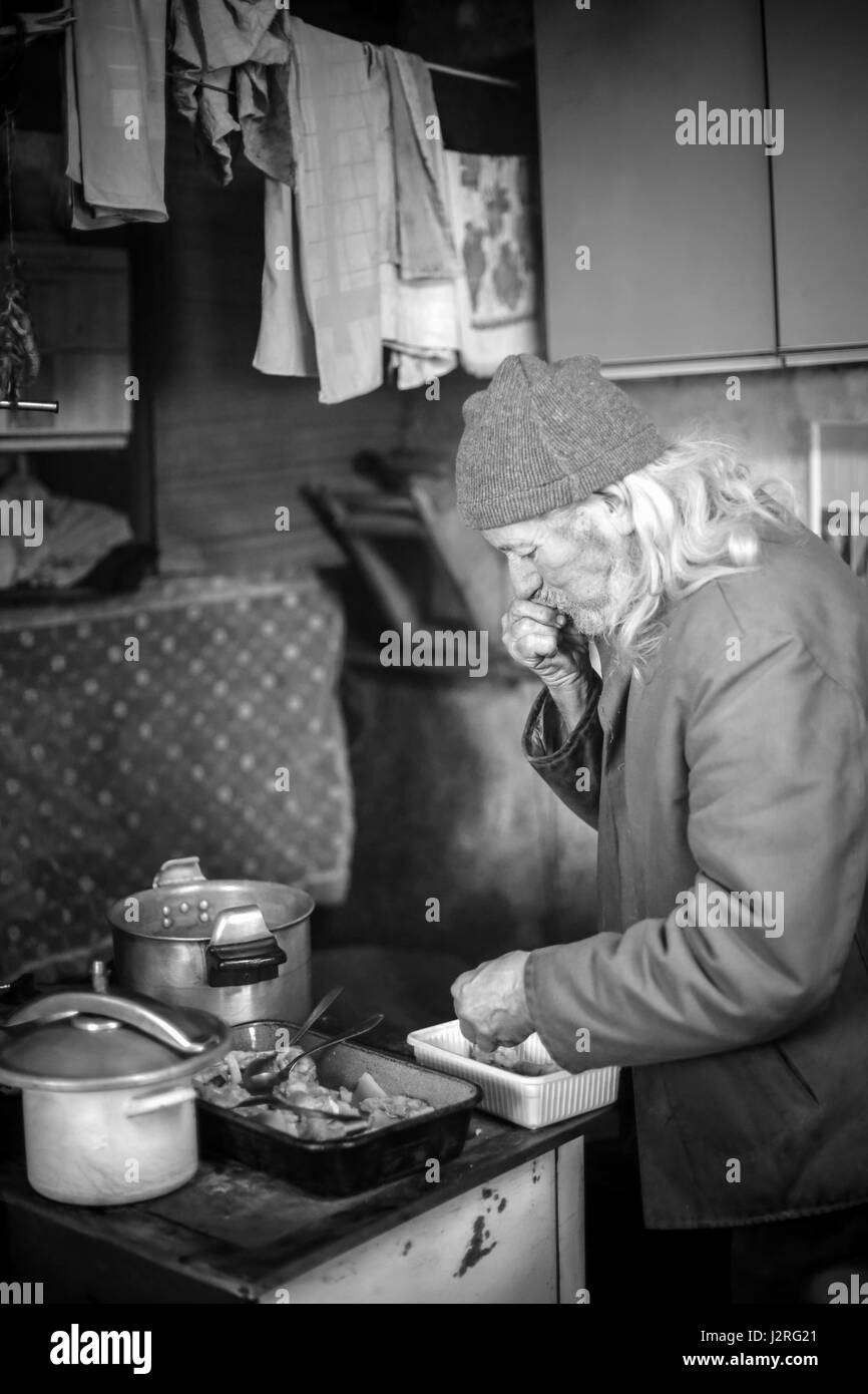 Ein Alter Mann kochen Schweinefleisch vorbereiten. Stockfoto