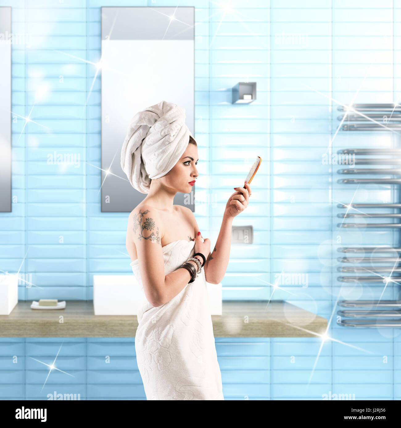 Frau mit Tattoo wäscht im Bad in ein Handtuch gewickelt Stockfoto