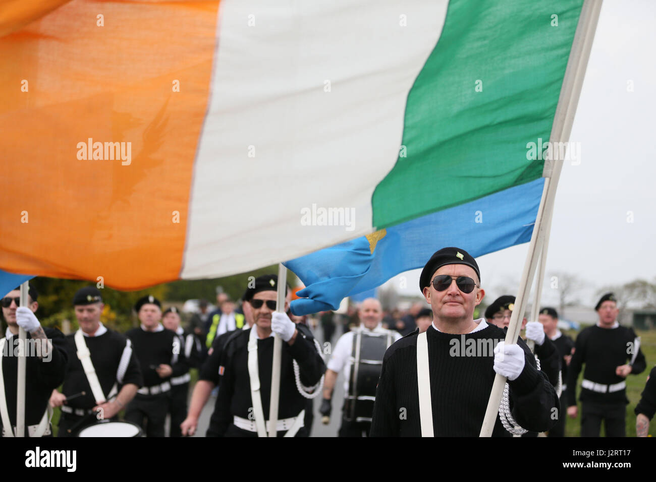 Ein Fahnenträger trägt die irische Trikolore während eines Marsches, Cappagh, Co Tyrone, anlässlich des 30. Jahrestages der schießenden Toten acht IRA-Mitglieder und Zuschauer Anthony Hughes in einem SAS-Hinterhalt in Loughgall, Co-Armagh. Stockfoto