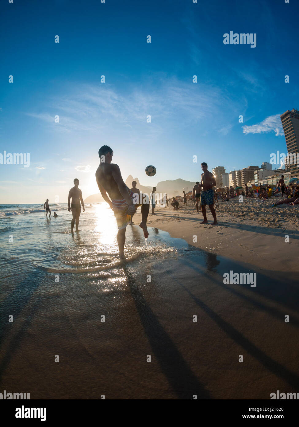 RIO DE JANEIRO - 2. Februar 2013: Junge Brasilianer spielen Altinho Beach-Fußball in einem keepy uppy Kreis bei Sonnenuntergang am Strand von Ipanema Strand. Stockfoto