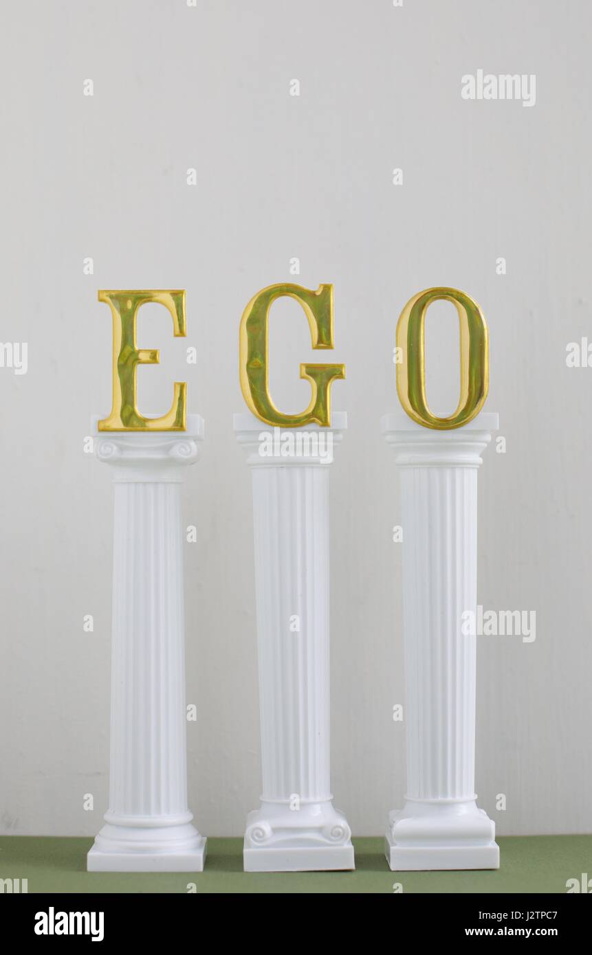 Das Wort "Ego" in großen goldenen Lettern auf Säulen. Stockfoto