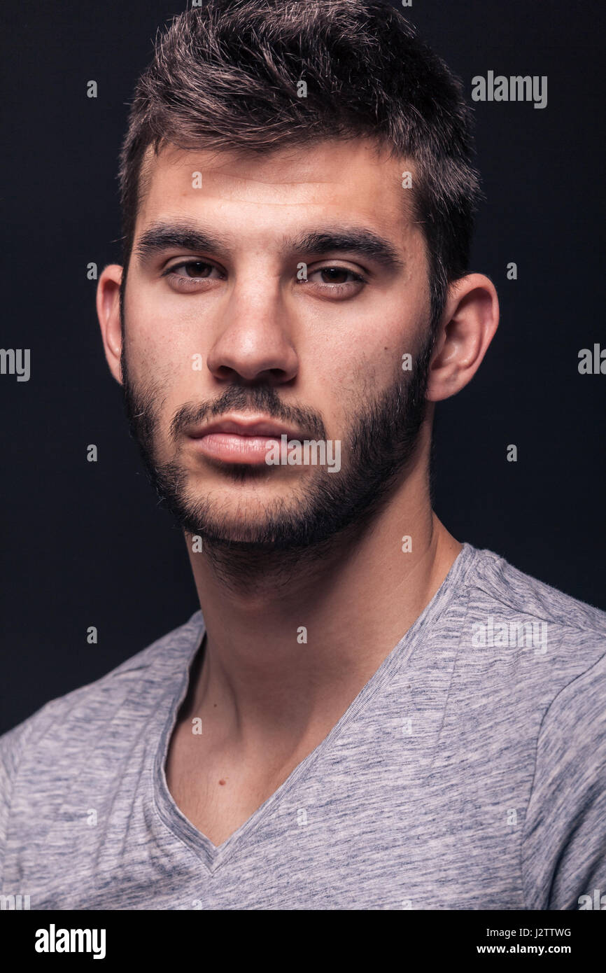 einem schönen jungen Mann, Porträt Gesicht Kopf Closeup, schwarzem Hintergrund studio Stockfoto