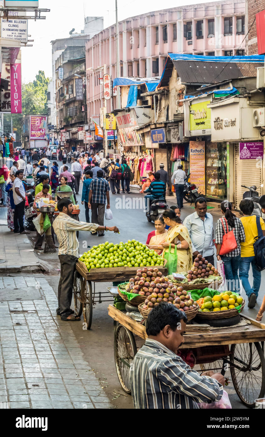 A Straßenszene in Pune, Indien mit Menschen, die mit Produkten von Karren. Stockfoto