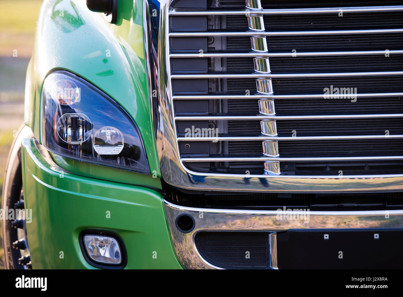 Sonnenbeschienenen leistungsstarke moderne stilvolle und komfortable grüne Sattelzug Sattelschlepper des neuesten Modells der kommerziellen Fernverkehr mit glänzenden Chrom-Kühlergrill Stockfoto