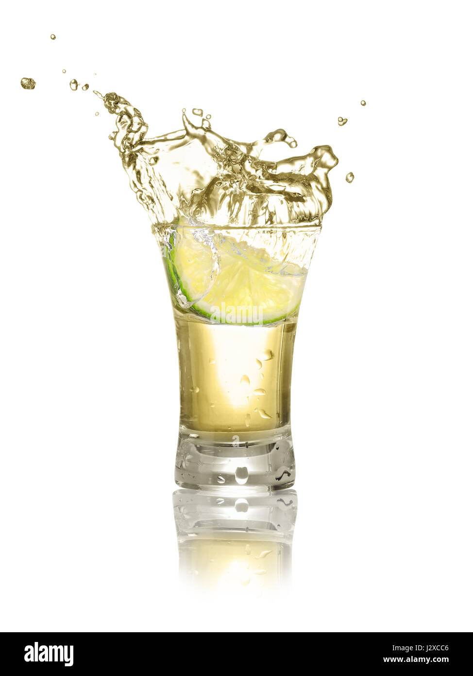 Gold Tequila shot mit Limettenscheibe und Spritzwasser isoliert auf weißem Hintergrund. Kalk fällt in den Alkohol trinken. Spritzer Tequila aus der fallenden pi Stockfoto