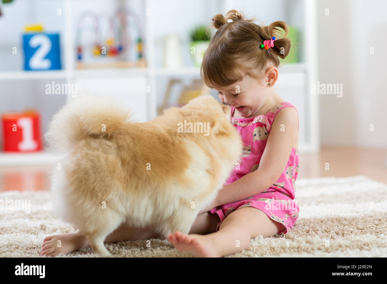 Lustige Kinder mit Hund Spitz zu Hause Stockfoto