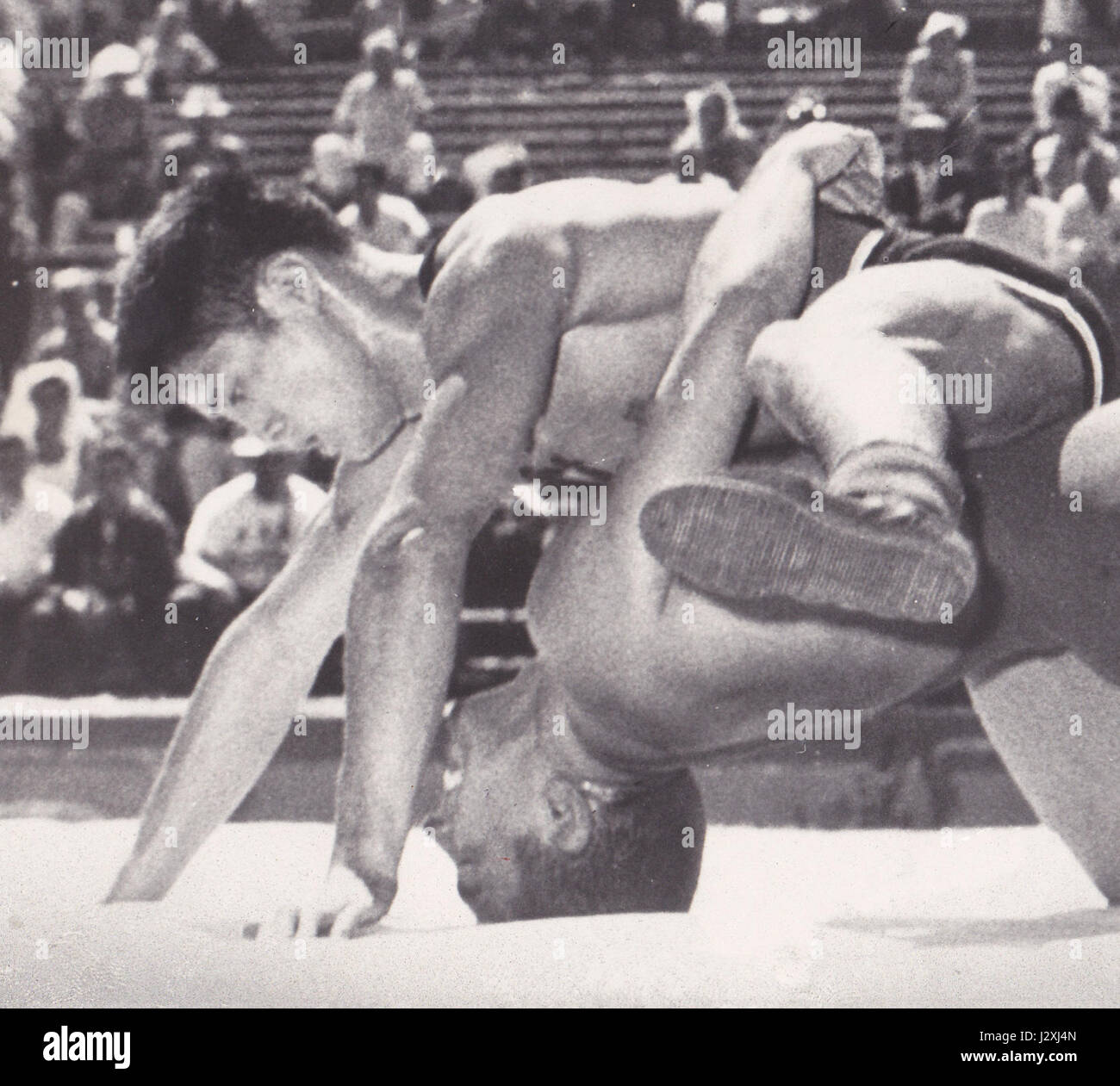 Masamitsu Ichiguchi trat 1960 bei einem Sportwettbewerb gegen Larry Lauchle an. Die Veranstaltung beinhaltete wahrscheinlich ein Kampfsport- oder Kampfsportspiel, was die sportlichen Fähigkeiten und den Wettkampfcharakter der Teilnehmer in dieser Zeit deutlich machte. Stockfoto