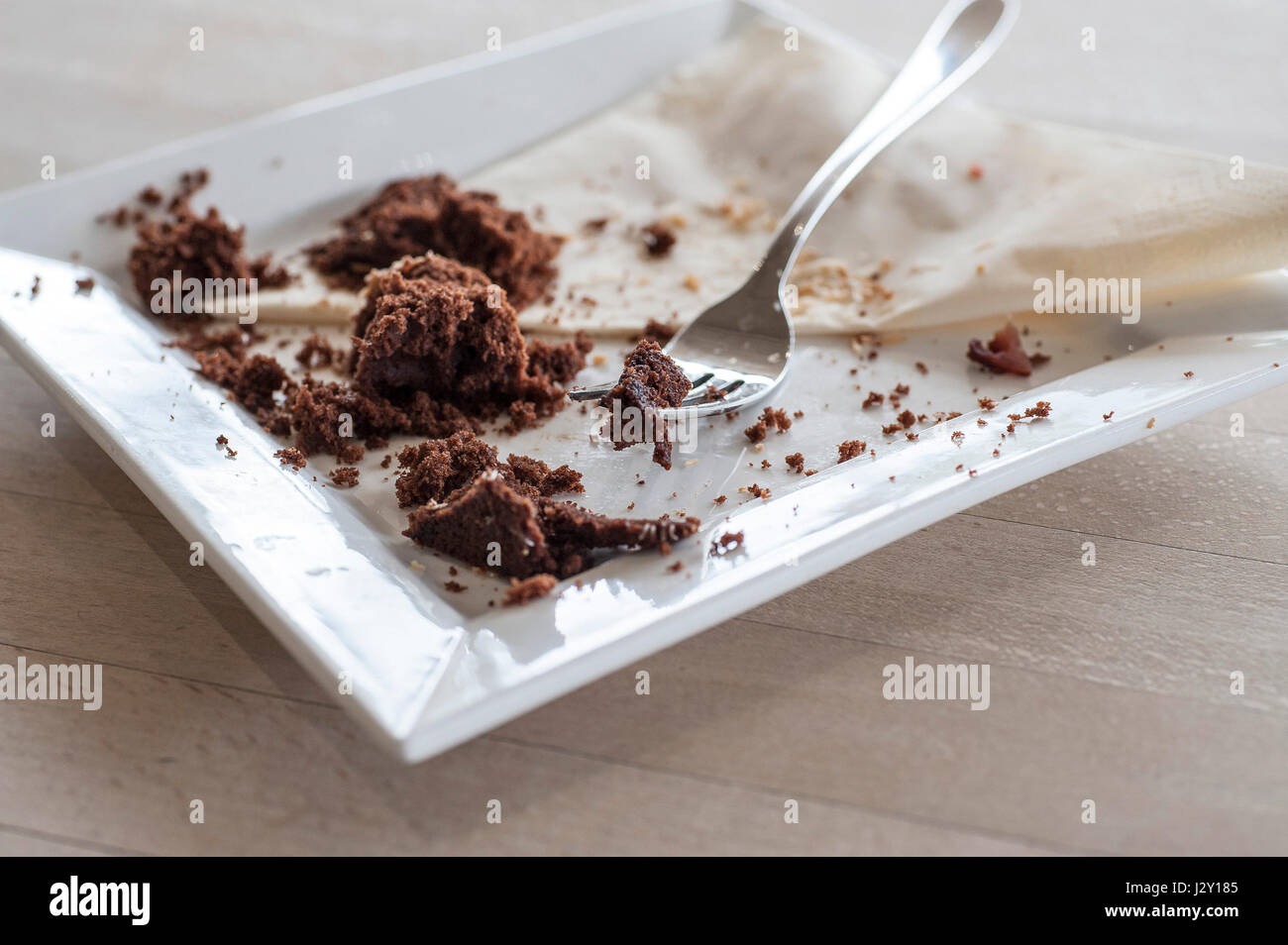 Speisereste ein Schokoladenkuchen Krümel Teller Gabel gegessen genossen behandeln zufrieden Stockfoto
