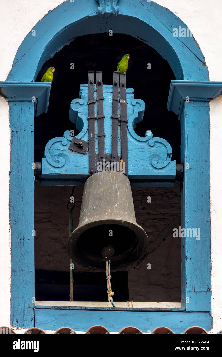 Nossa Senhora Dos Anjos Kapelle Glocke mit grüner Papagei Vögel - Mariana, Minas Gerais, Brasilien Stockfoto