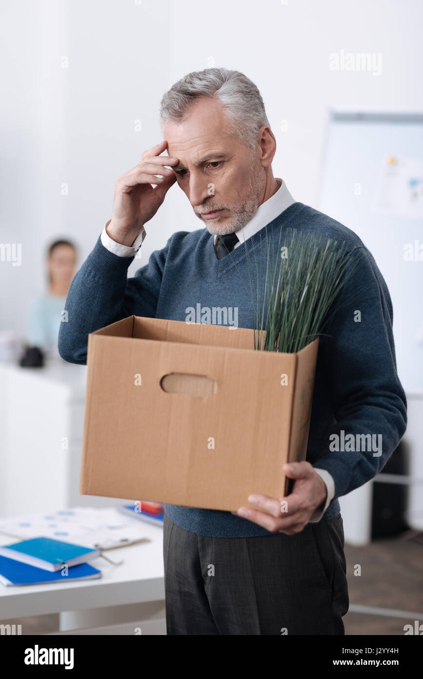 Nachdenklicher Mann im Jahre stehen im Büro Stockfoto