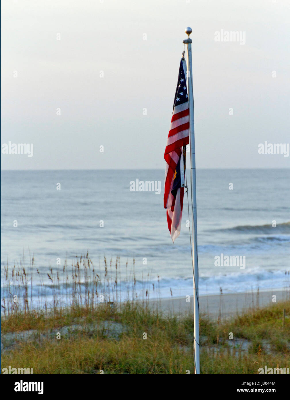 Ein deflationiert amerikanische Flagge hängen schlaff steif Fahnenmast durch ein mutloser scheinbaren und stumpf suchen Shining Sea Stockfoto